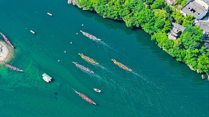 ↑在安徽省宣城市泾县桃花潭镇，数支龙舟队在参与当地举办的龙舟赛，迎接端午节的到来（2025年5月30日摄，无人机照片）。
