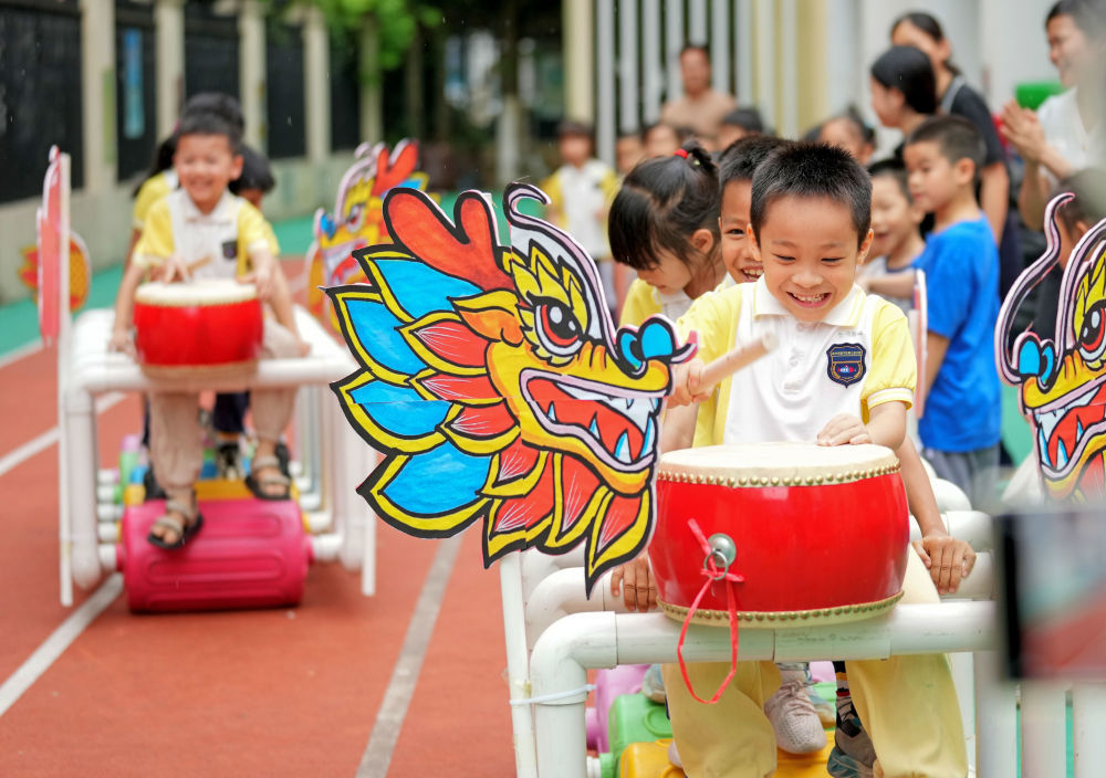 ↑在广西自治区南宁市邕宁区第三幼儿园，小朋友进行旱地划龙舟比赛（2025年5月28日摄）。