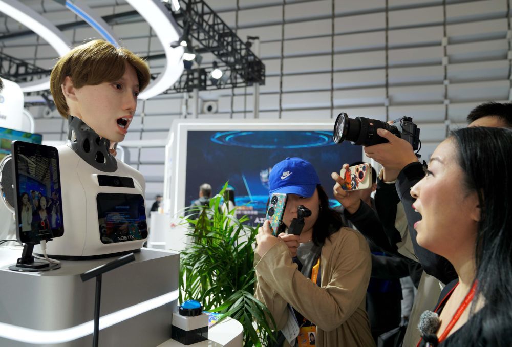 ↑ 11月6日,一名工作人员与一款松延动力仿生机器人互动。这款自主研发的仿生机器人采用高精密执行器,结合仿生人本体与控制算法,可实时识别并模仿互动对象的各种面部表情。新华社记者赵宇思摄