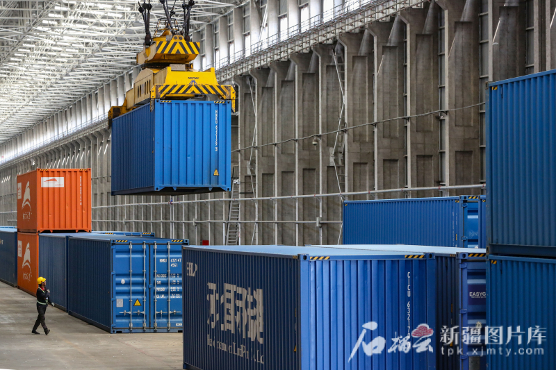 6月24日，阿拉山口站中欧（中亚）班列换装区内的行车在吊装集装箱。