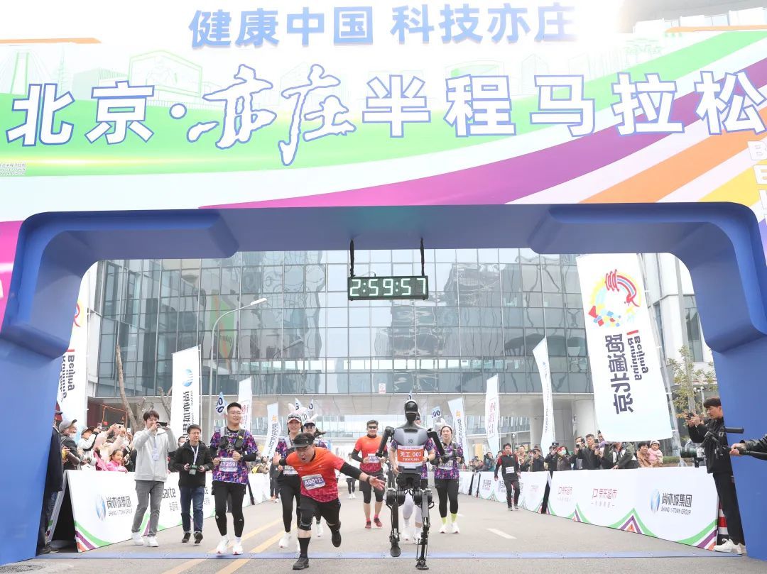 在2024北京亦庄半程马拉松赛事上,人形机器人“天工”化身“关门兔”与选手一起冲过终点。资料图