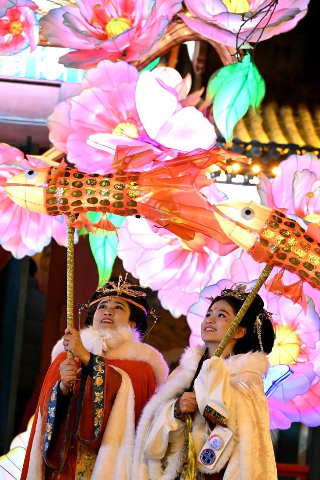 2月8日晚,身着传统服饰的游人在河北省石家庄市正定荣国府影视基地内游园赏花灯。新华社发(陈其保摄)