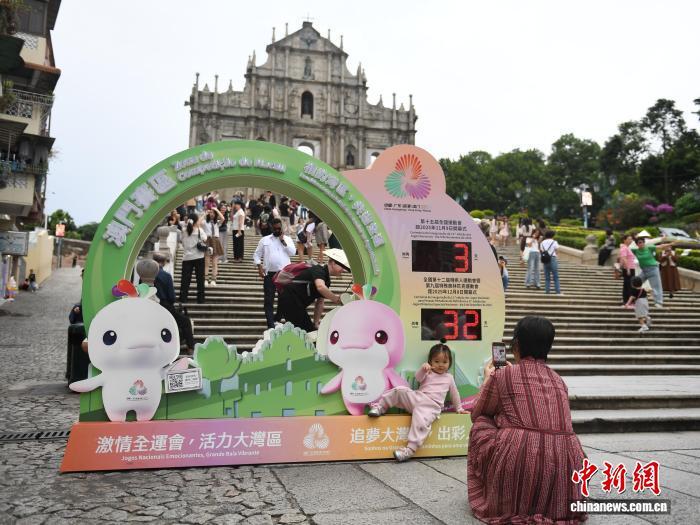 11月6日,游客在澳门“大三巴”牌坊前的第十五届全国运动会倒计时装置前拍照留念。中新社记者 郑嘉伟 摄