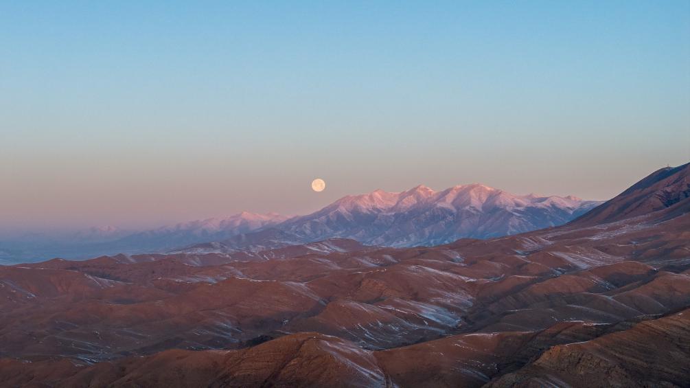 这是1月14日在新乌鞘岭隧道附近拍摄的山脉与月亮（无人机照片）。新华社记者 郎兵兵 摄