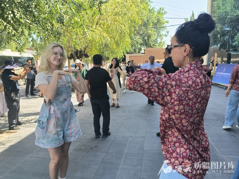 7月24日，梅丽莎（左）在额敏县榆柳巷跟着居民学跳舞。石榴云/新疆日报记者 甘兴华摄