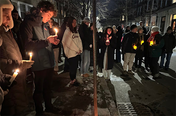 一群人聚集在洛雷罗公寓外悼念。 美联社