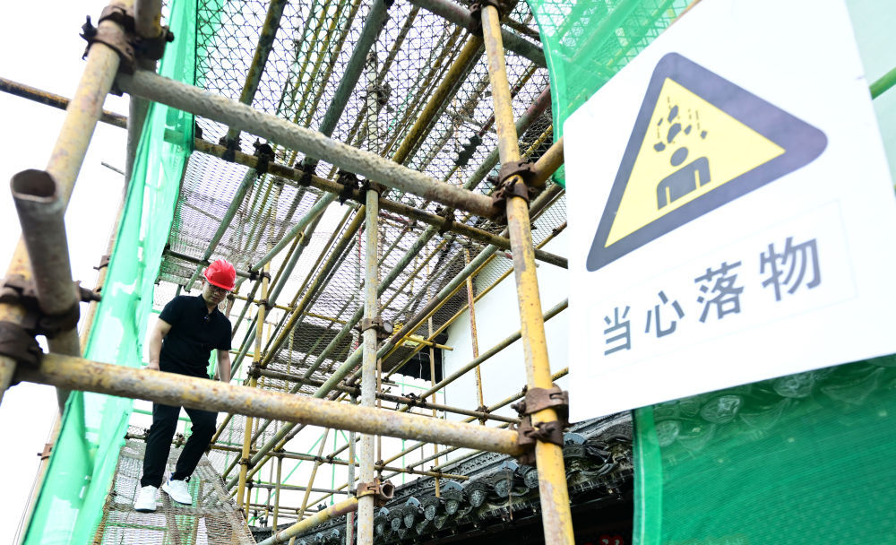 6月19日,周虎在歙县徽州古城南谯楼保养维护工程现场查看。