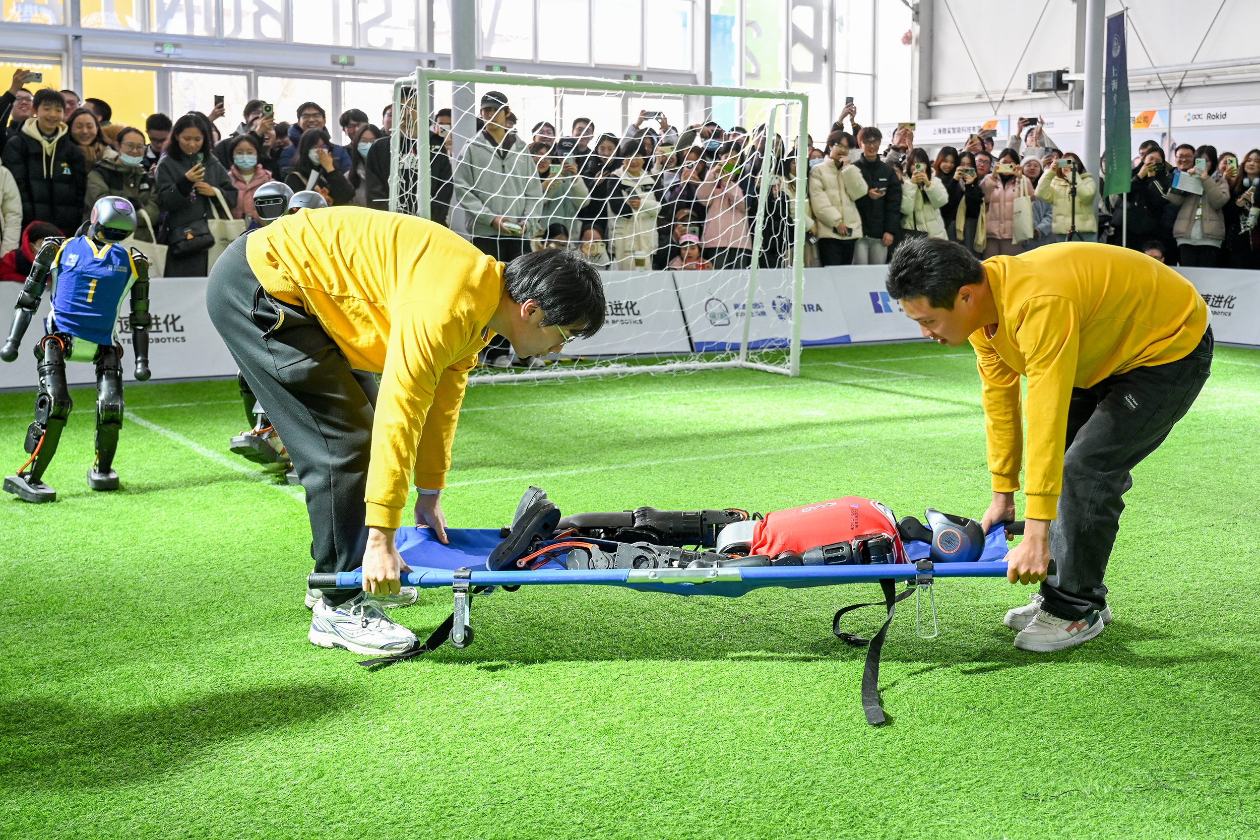2025年2月22日,上海西岸艺术中心,在足球比赛中“受伤”的机器人被工作人员用担架抬了下去。澎湃新闻记者 朱伟辉 图