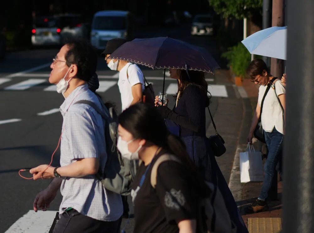 6月18日,在日本东京,行人在街头行走。新华社记者贾浩成摄