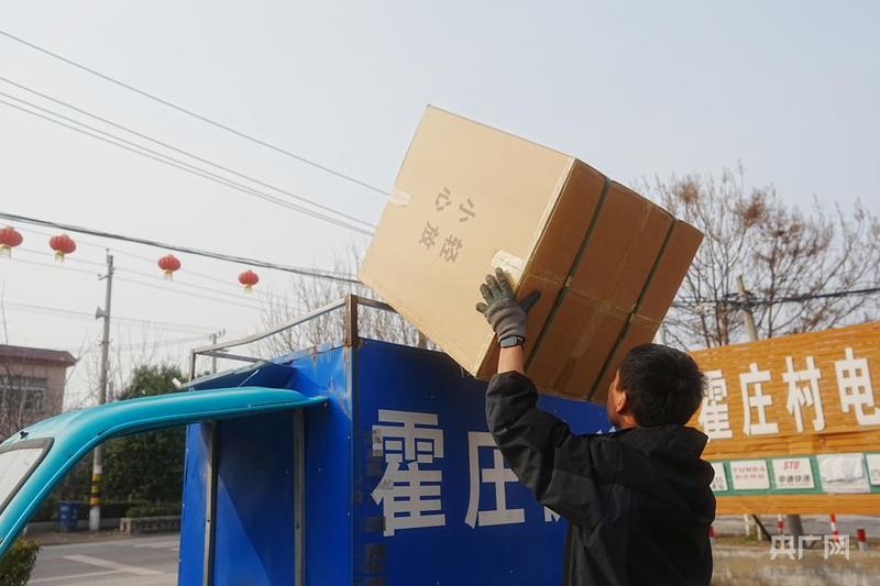 快递员尤忠平正在卸货（央广网发 刘猛猛 摄）