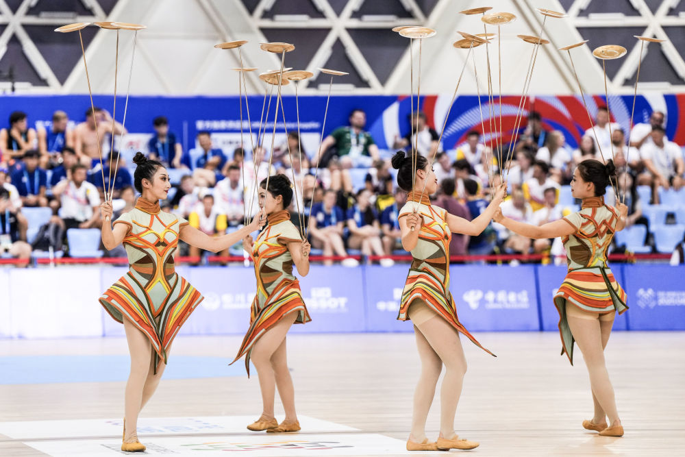 ↑8月12日,演员在成都世运会荷球混合团体赛决赛铜牌赛间隙进行杂技表演。