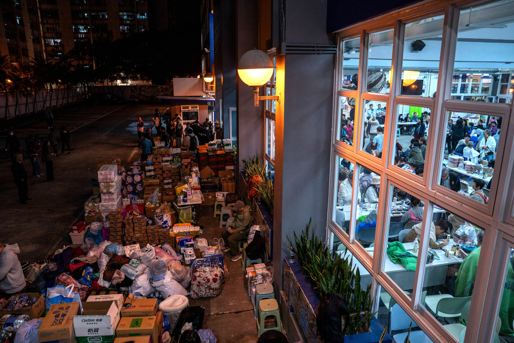 11月26日晚,香港,一所学校作为临时避难所,工作人员正在搬运消防物资。