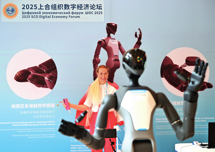 参会嘉宾在天津举行的2025上合组织数字经济论坛上体验操控人形机器人（2025年7月11日摄）李然摄/本刊