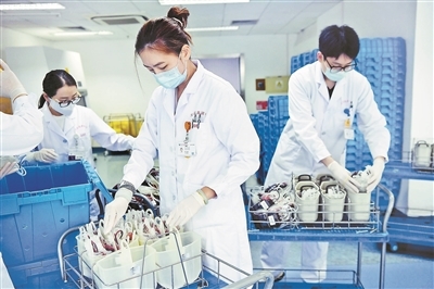 工作人员将血液送入离心机