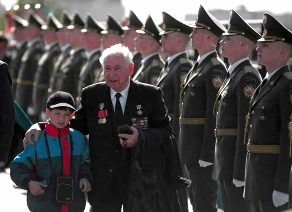 2001年5月9日,在俄罗斯莫斯科,一名老兵带着晚辈参加纪念卫国战争胜利56周年阅兵式。新华社记者王长山摄