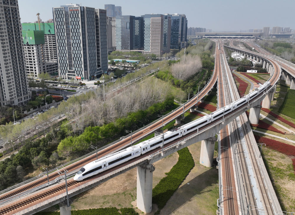 2025年3月31日，一列動(dòng)車組列車駛出鄭州東站（無(wú)人機(jī)照片）,。新華社記者 李嘉南 攝