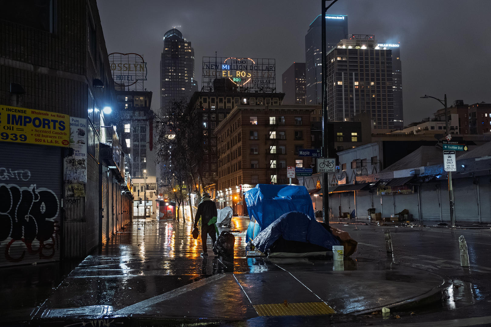 ▲当地时间2025年12月24日,美国加州,雨中在洛杉矶市中心街头露宿的无家可归的人 图据视觉中国