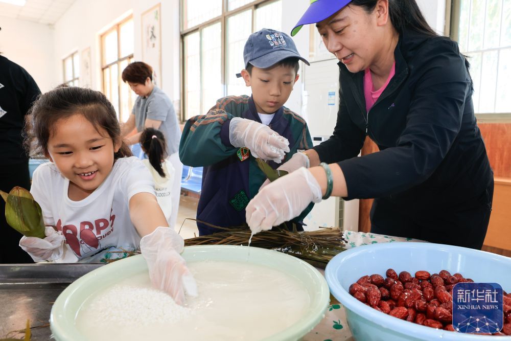 ↑ 5月24日，在河北省唐山市丰南区开展的“粽子飘香迎端午”主题活动中，胥各庄镇小王庄村村民在包粽子。新华社发（李秀清摄）
