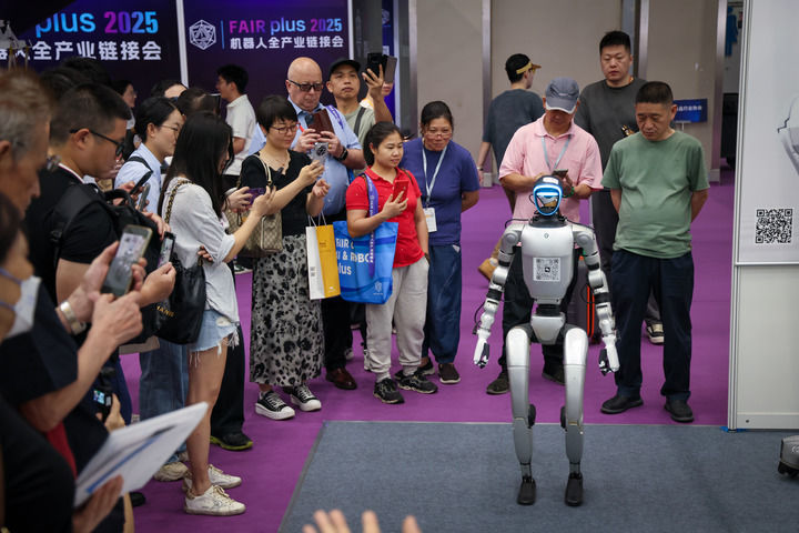 在深圳会展中心，参观者在首届机器人全产业链接会上的宇树科技展台观看人形机器人展示（2025年4月24日摄）。新华社记者 毛思倩 摄