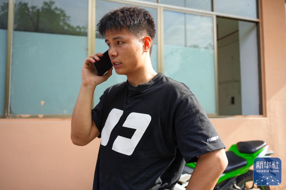 6月25日，林进标在榕江街头与家人通话联系。