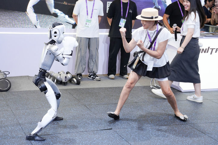 2025年9月19日，在广西南宁国际会展中心人工智能专馆，一台人形机器人和观众表演拳击。新华社记者 周汀鹭 摄