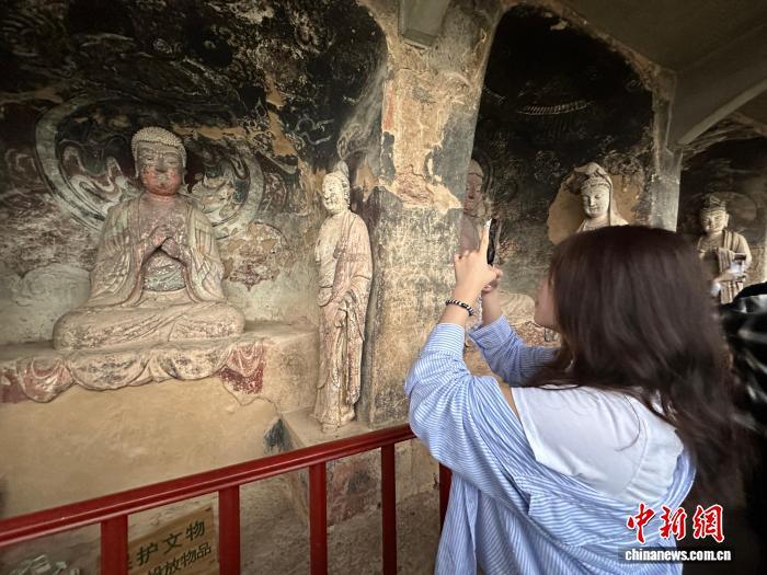 图为台青驻足参观石窟塑像 王牧雨 摄