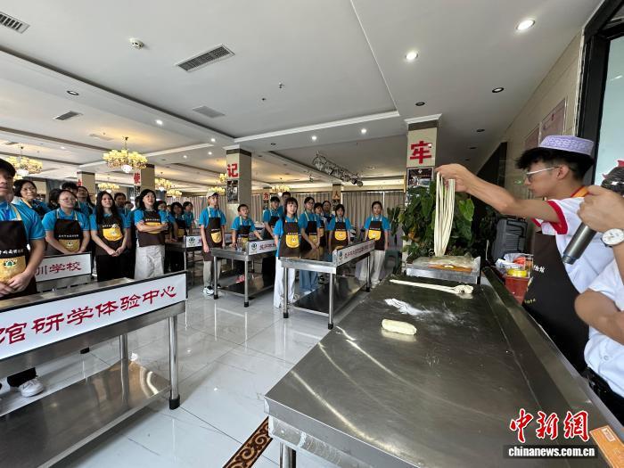 8月2日,由甘肃省委统战部、香港甘肃联谊会主办的“相约如意甘肃·厚植爱国情怀”第二届香港青少年国情研学活动一行走进兰州牛肉面博物馆,随着讲解员“一清、二白、三红、四绿、五黄”的介绍和不同面型的拉面演示,团员们亲手体验了牛肉面的制作过程,随后品尝了这道特色美食。港青们纷纷表示,拉面过程看似简单,其实里面的门道还有很多。图为牛肉面拉面师傅向来自香港的青少年们演示拉面技艺。王牧雨 摄