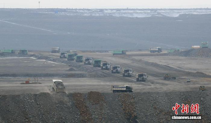 图为在准东宜化五彩湾一号露天煤矿有序作业的各种大型车辆。中新网记者 孙亭文 摄