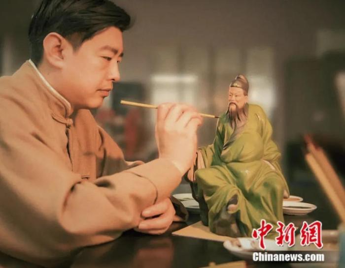 图为“泥人张世家”第六代传人张宇正在为泥塑绘色
