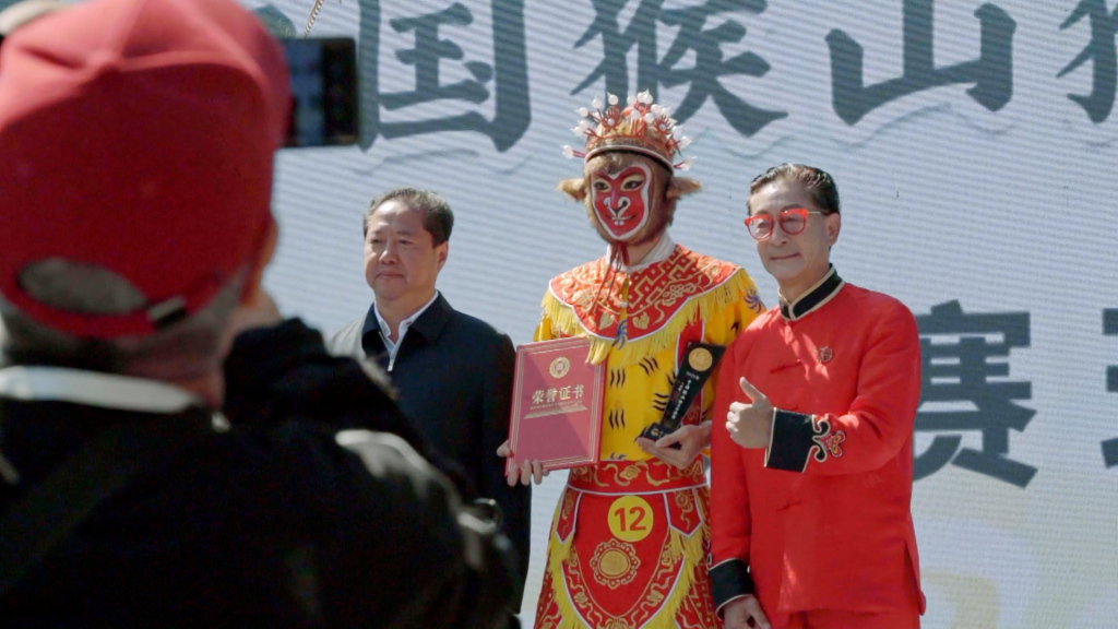 首届中国猴山猴王争霸赛上,六小龄童为获奖者颁奖。