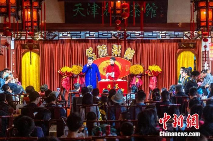 图为游客在天津名流茶馆感受传统相声文化