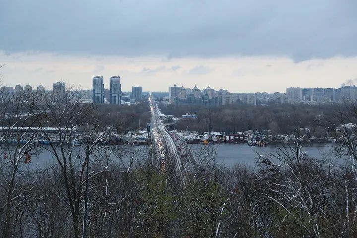 这是2024年11月21日在乌克兰首都基辅拍摄的白雪映衬下的地铁桥和第聂伯河。新华社记者 李东旭 摄