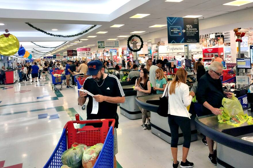 2025年5月,一位阿根廷居民在超市购物完后检查小票。(阿根廷《国民报》)