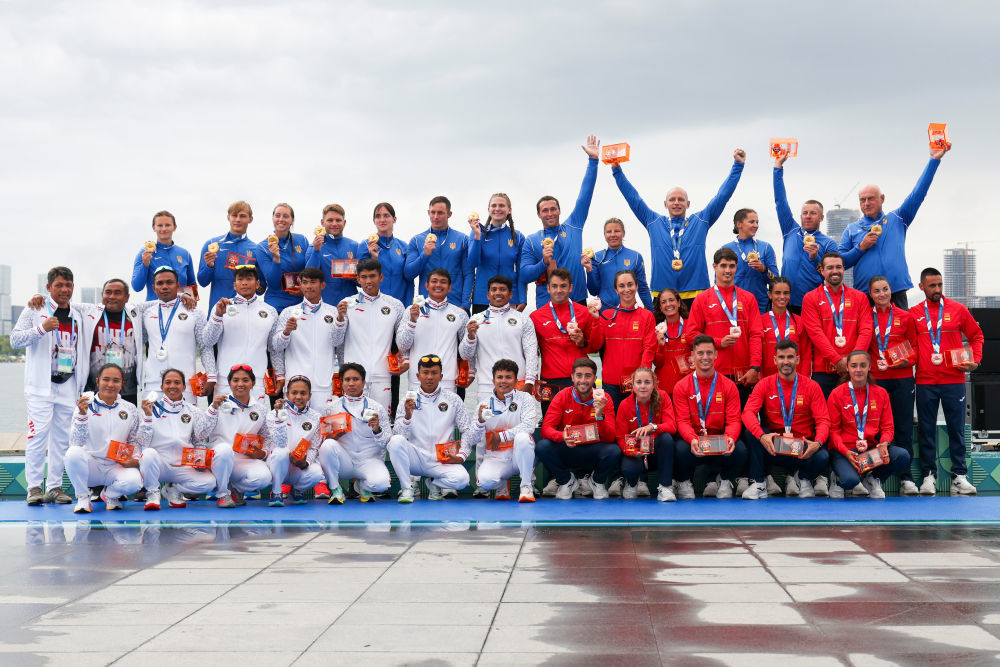 8月10日,冠军乌克兰队(后)、亚军印度尼西亚队(前左)、季军西班牙队(前右)在龙舟10人座2000米追逐赛颁奖仪式上。新华社记者 王翔 摄