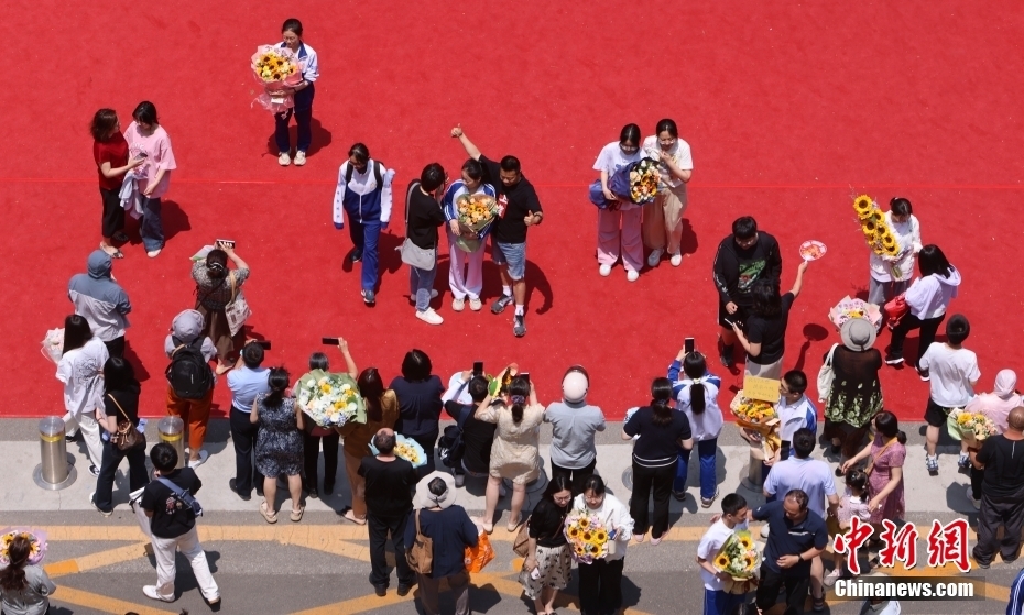 资料图：6月10日，北京市首师大附中通州校区考点外，考生走出考点接受亲人的祝福。 中新社记者 杨可佳 摄
