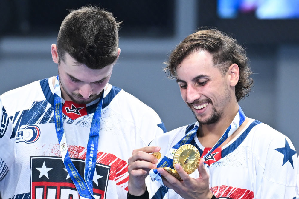 ↑8月11日,冠军美国队球员在成都世运会男子单排轮滑球颁奖仪式上查看奖牌。