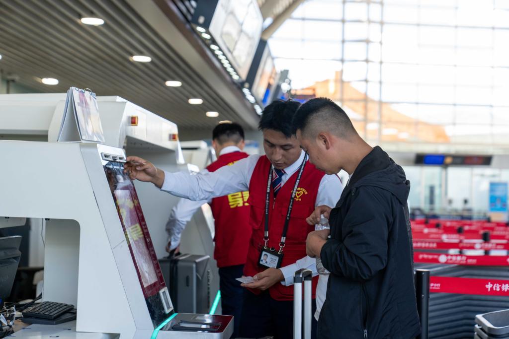 7月18日,拉萨贡嘎国际机场工作人员在帮旅客办理行李托运手续。新华社记者旦增尼玛曲珠 摄