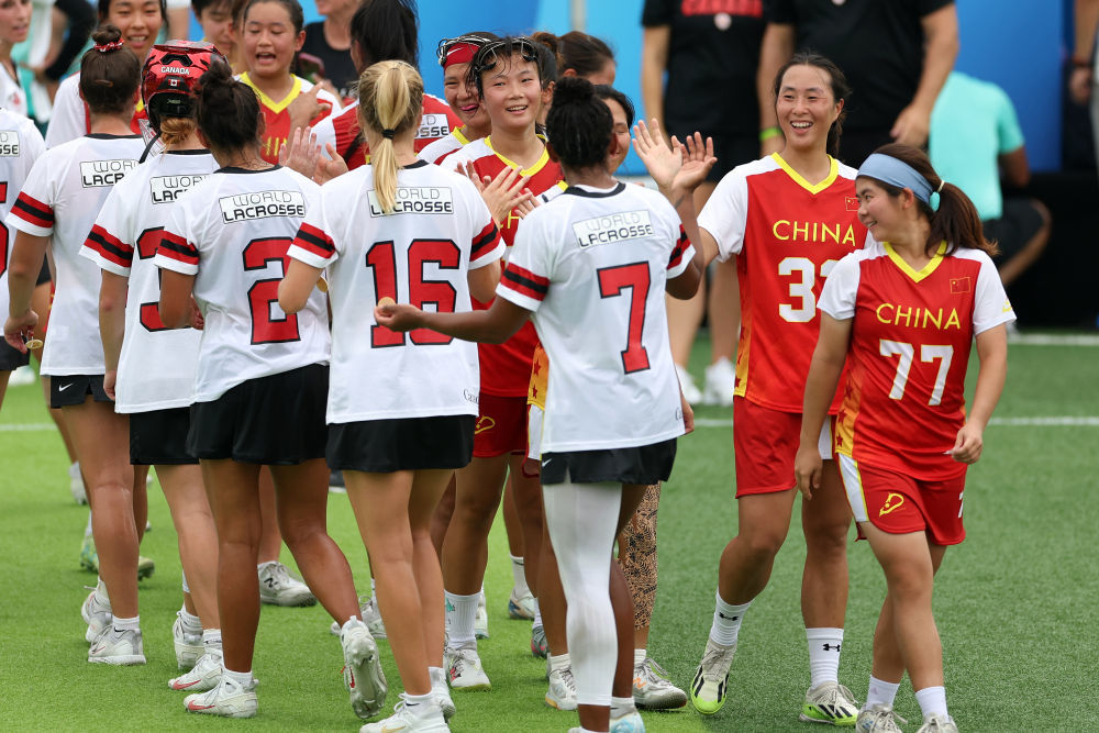 8月9日,中国棍网球队球员与加拿大队球员赛后击掌致意。新华社记者 陈斌 摄