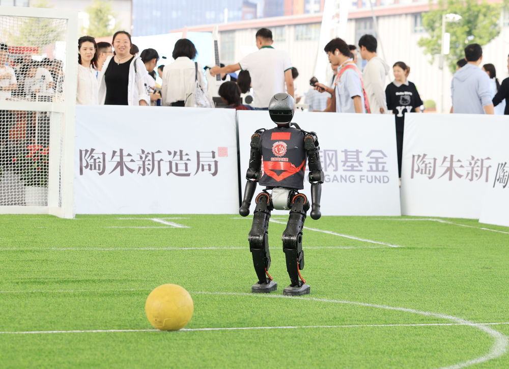 ↑ 这是9月11日在体育服务专题展区拍摄的一款人形机器人演示踢足球。