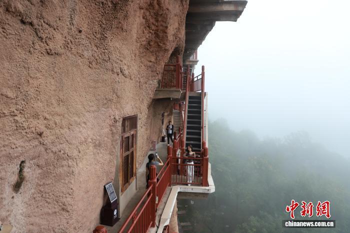 图为台青在麦积山石窟栈道上拍照留影 岳建忠 摄