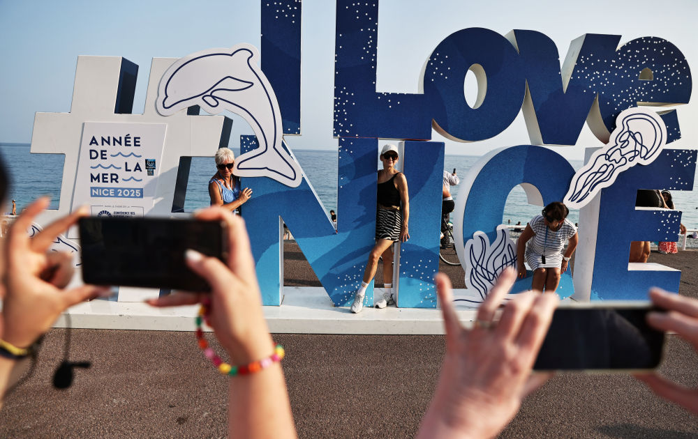 6月10日，在法国尼斯的盎格鲁街上，人们在国际海洋年和第三届联合国海洋大会主题的景观前拍照。新华社记者 高静 摄