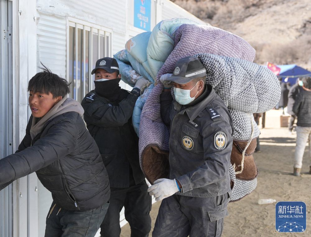 1月10日，在定日县长所乡古荣村，警察帮助受灾群众将物品从帐篷搬至板房。新华社记者 晋美多吉 摄