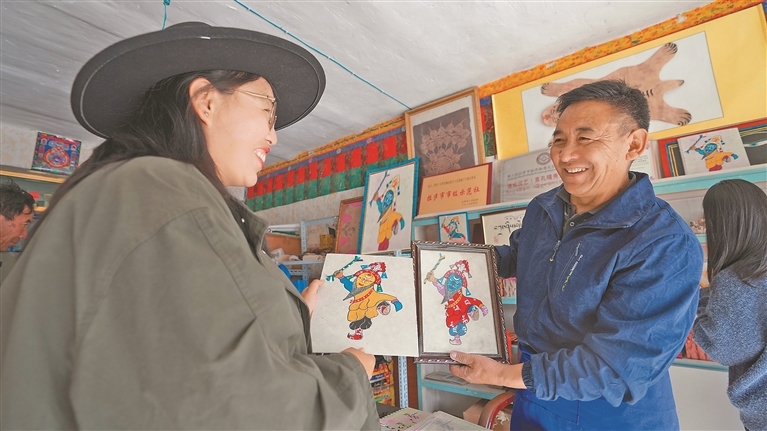 图为阿旺曲央在展示藏纸文创产品。