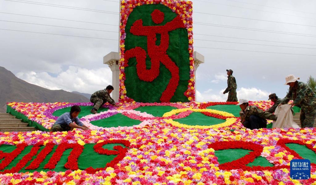 2008年4月29日,拉萨市园林工人在布置花卉景观。当时,拉萨市区的主要街道摆放了花卉和奥运标志,迎接北京奥运会倒计时100天。