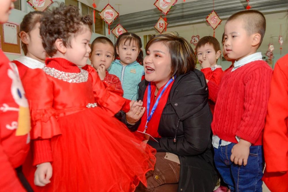 全国人大代表如克亚木（右三）在集中视察活动中，来到新疆鄯善县中心幼儿园与孩子们交谈（2019年2月14日摄）。新华社记者丁磊摄