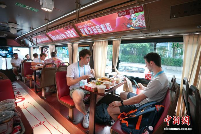 8月6日晚,成都世运会外籍运动员等在火锅巴士上品成都火锅。 中新社记者 安源 摄