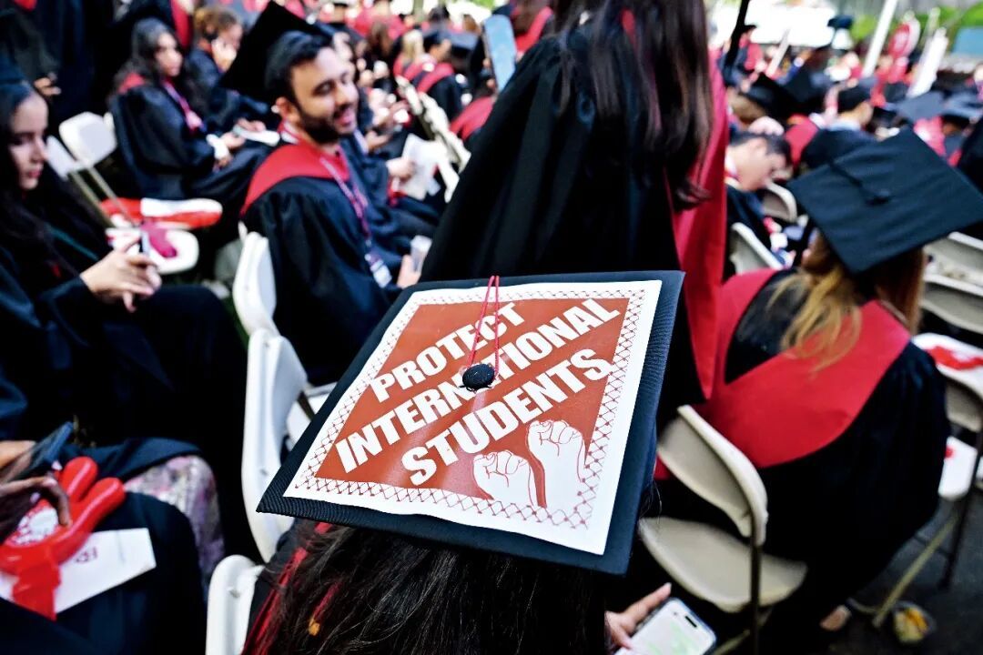 2025年5月29日,美国哈佛大学的毕业典礼上,一些毕业生的学位帽上写着“支持国际学生”的字样。图/视觉中国