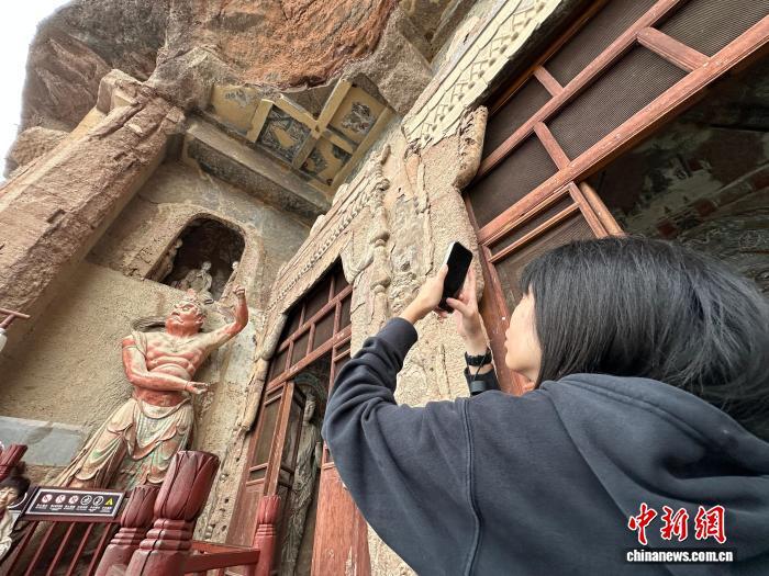 图为台青在麦积山石窟拍照留影 王牧雨 摄