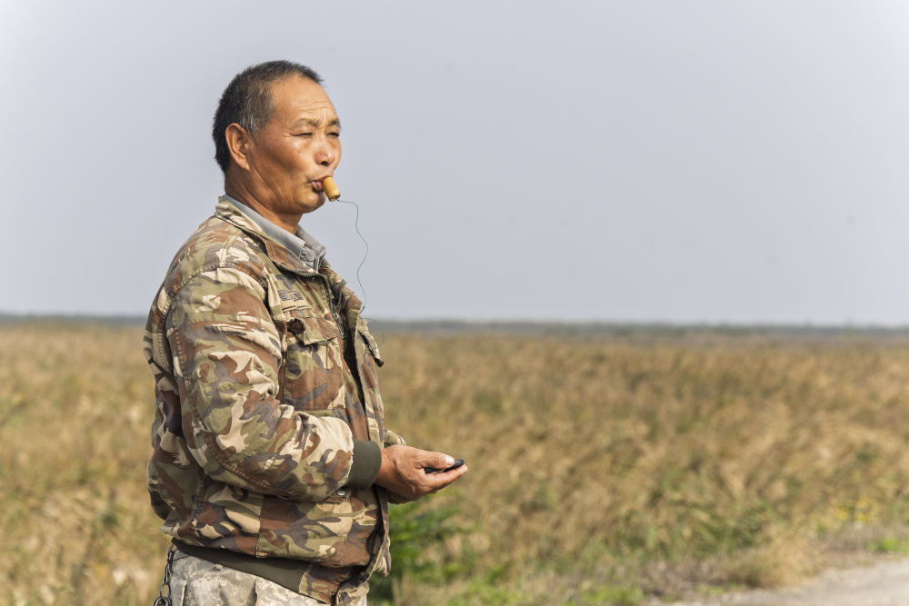 2024年11月12日，金伟国在上海崇明东滩鸟类国家级自然保护区吹鸟哨。新华社记者 王翔 摄
