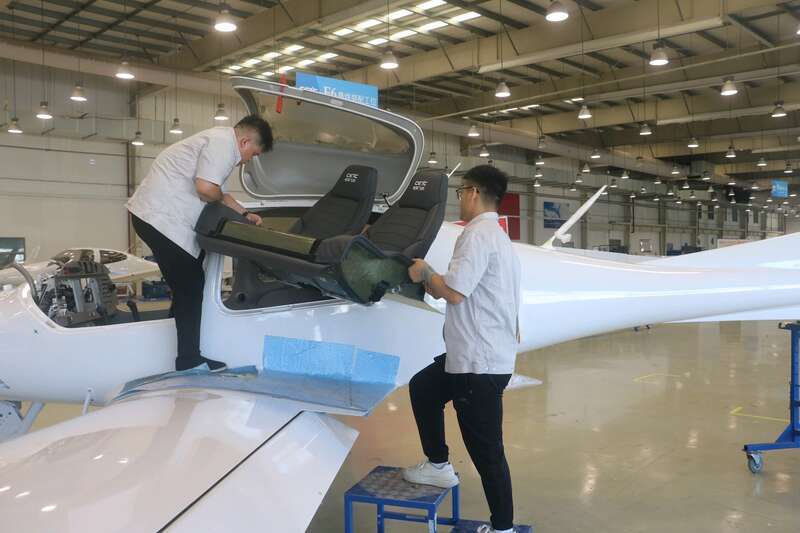 两位年轻职工正在为飞机安装座椅。中青报&middot;中青网记者 王海涵/摄